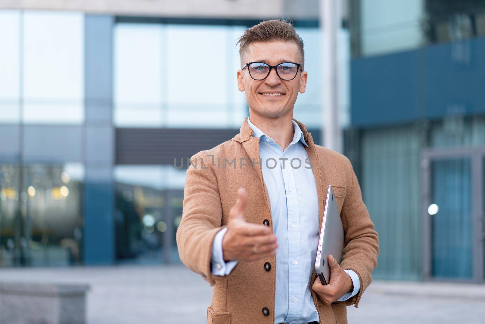 Business. Businessman Giving Hand For Handshake Welcome Gesture Adult Caucasian Male Business Person Holding Closed Laptop Give Hand Ready Handshake Office Building Background