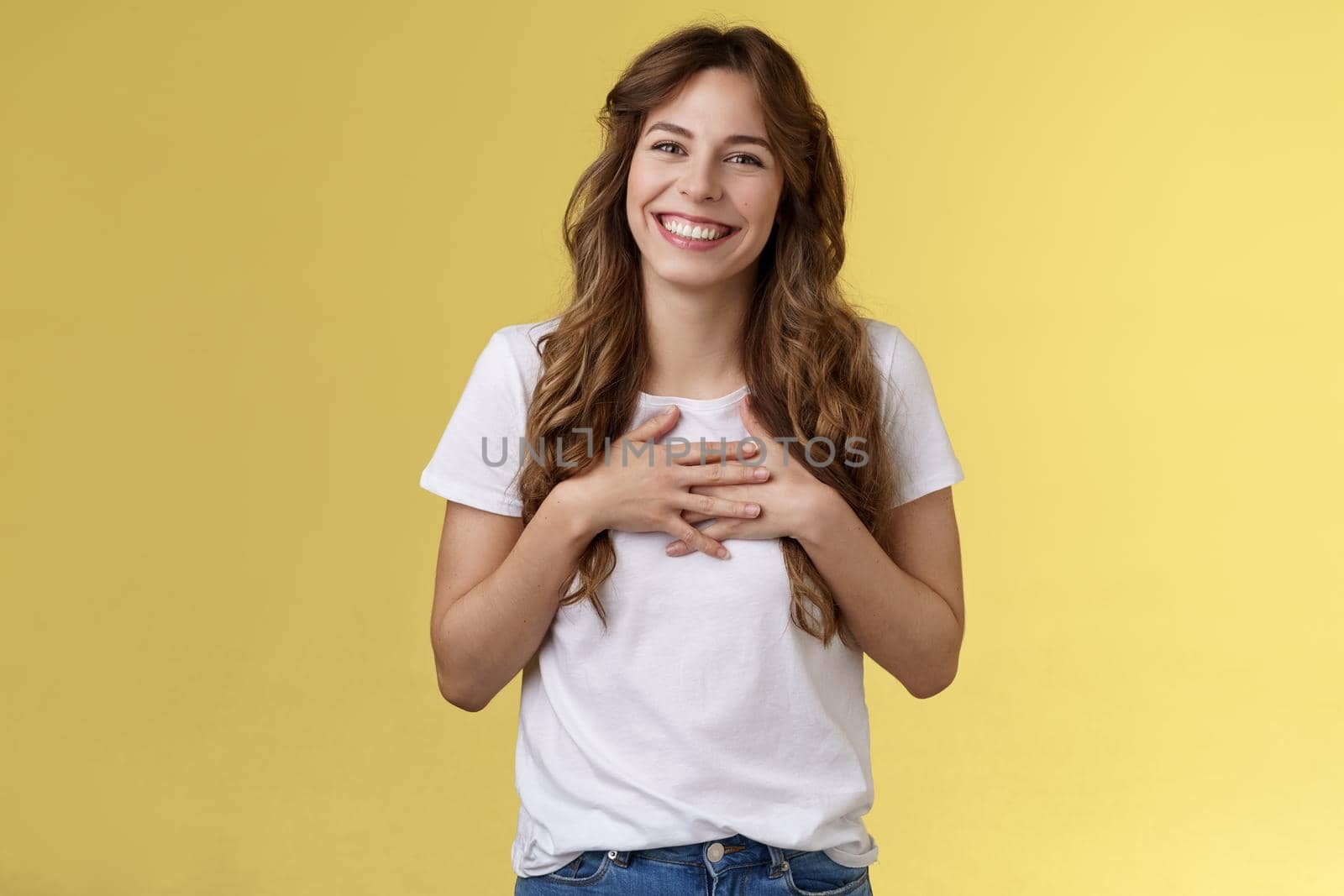 Girl thanking gladly awesome opportunity part of team smiling grateful press palms heart grinning tilt head lovely amused thankful gaze camera delighted stand yellow background. Copy space