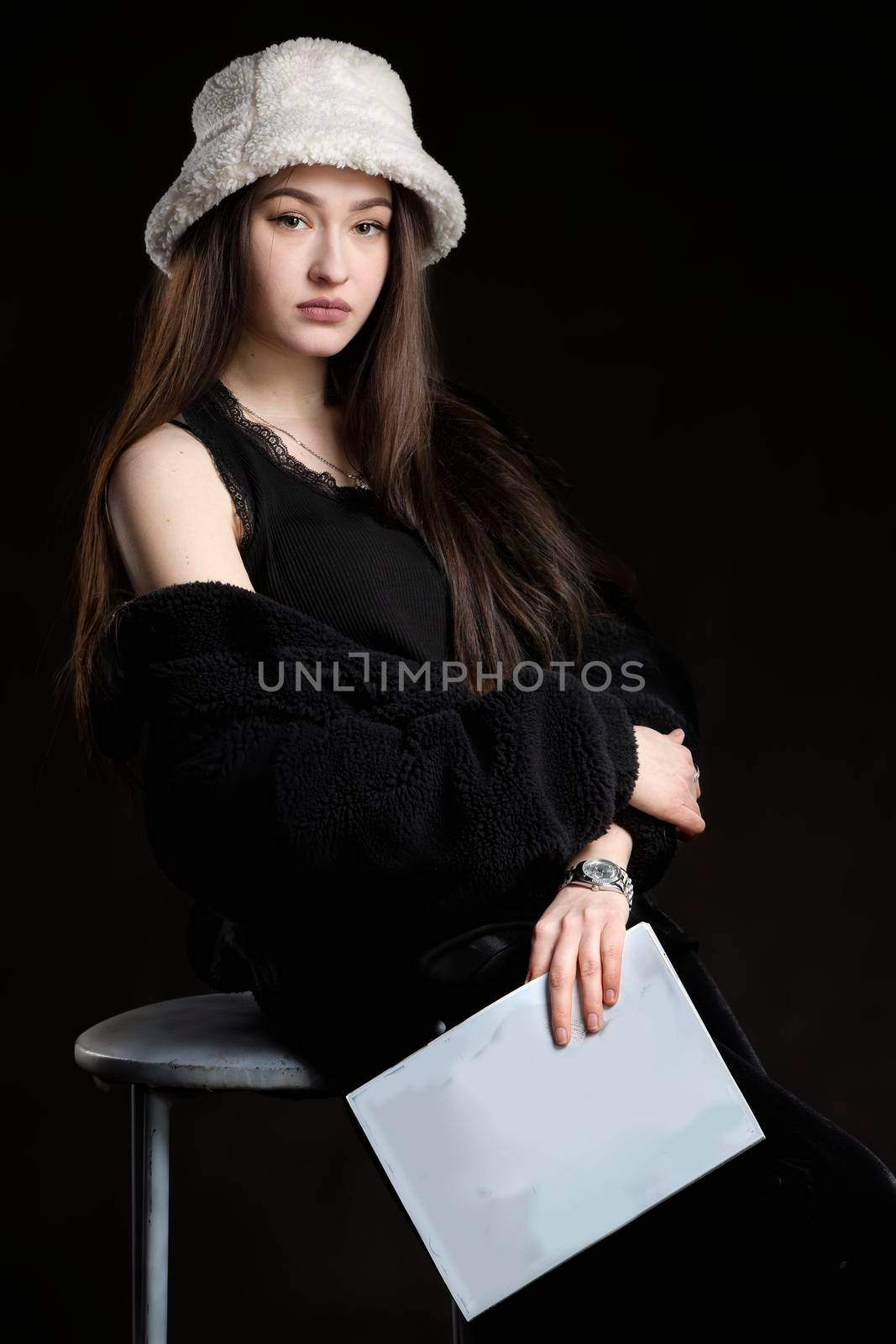 Beautiful brunette girl with white magazine in hand.