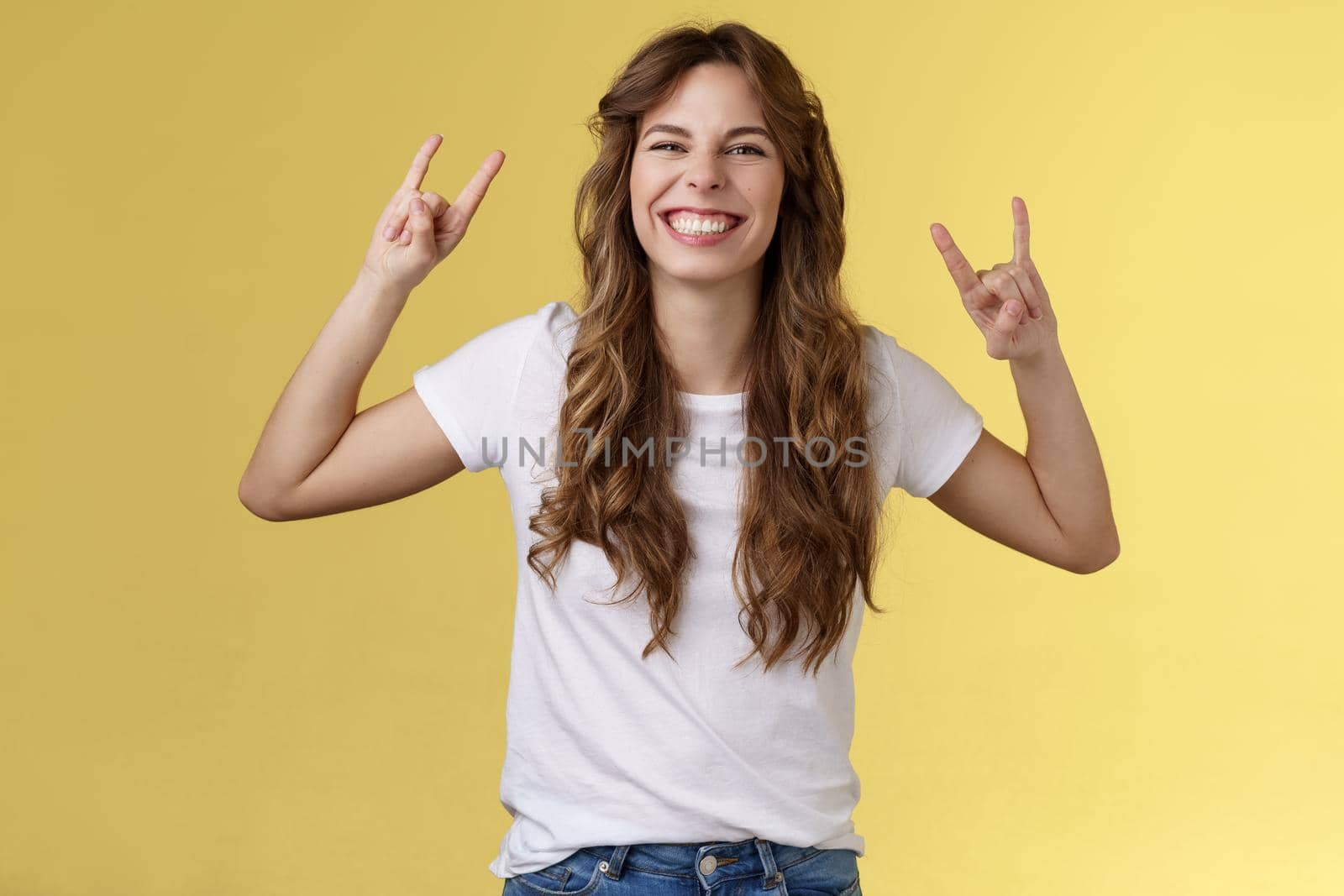 Enthusiastic charismatic lucky girl having fun enjoy awesome music show rock-n-roll gesture grinning thrilled like heavy-metal dancing upbeat positive standing entertained yellow background. Lifestyle.