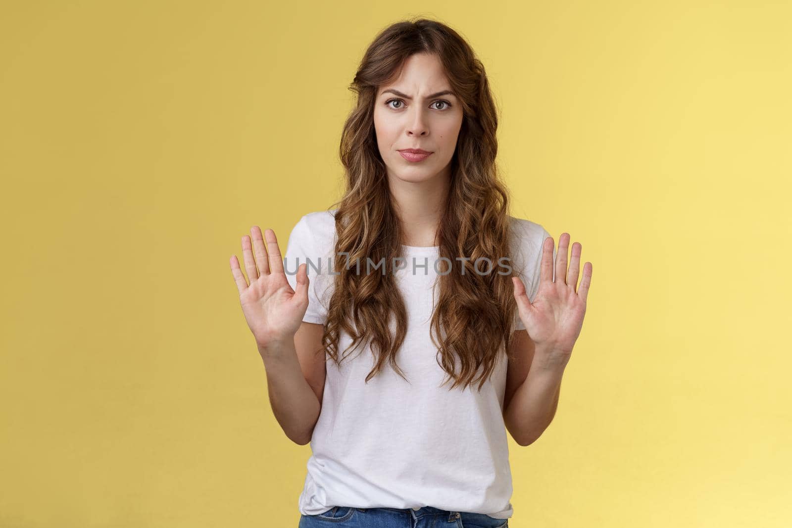 No thats enough. Serious-looking confident woman restrain man demand stay away give refusal look intense prohibit rejecting suspicious unpleasant offer stand yellow background. Copy space