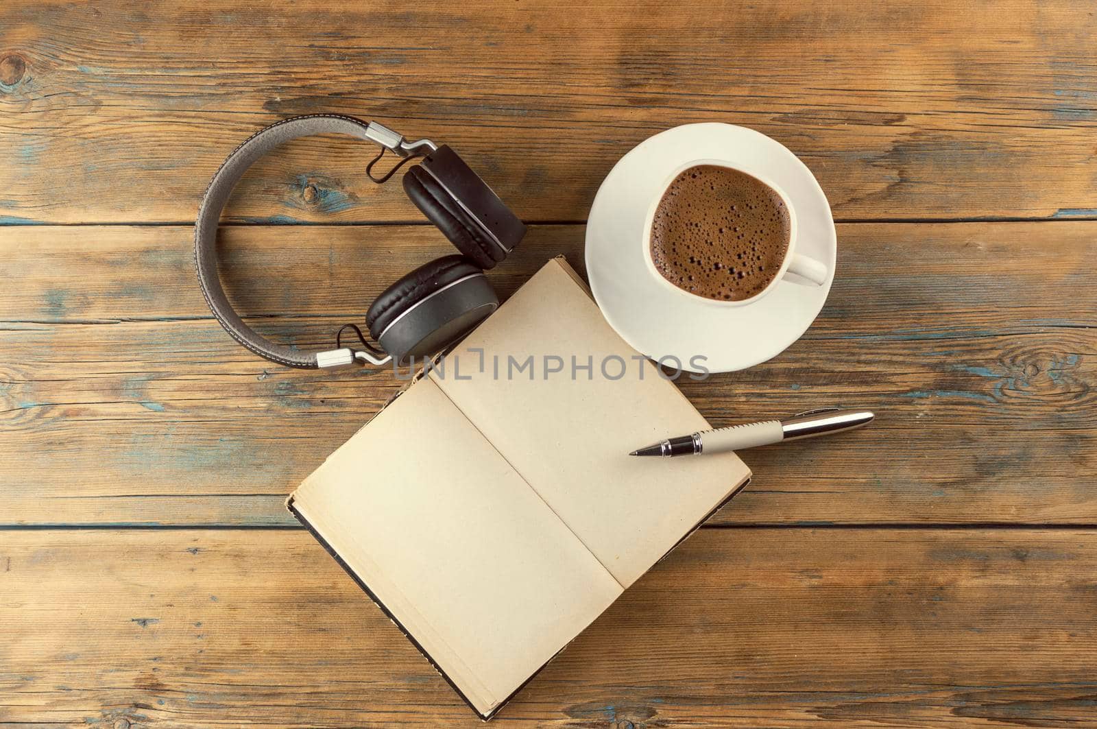Open a blank page book, pen and cup of coffee on the desk by inxti