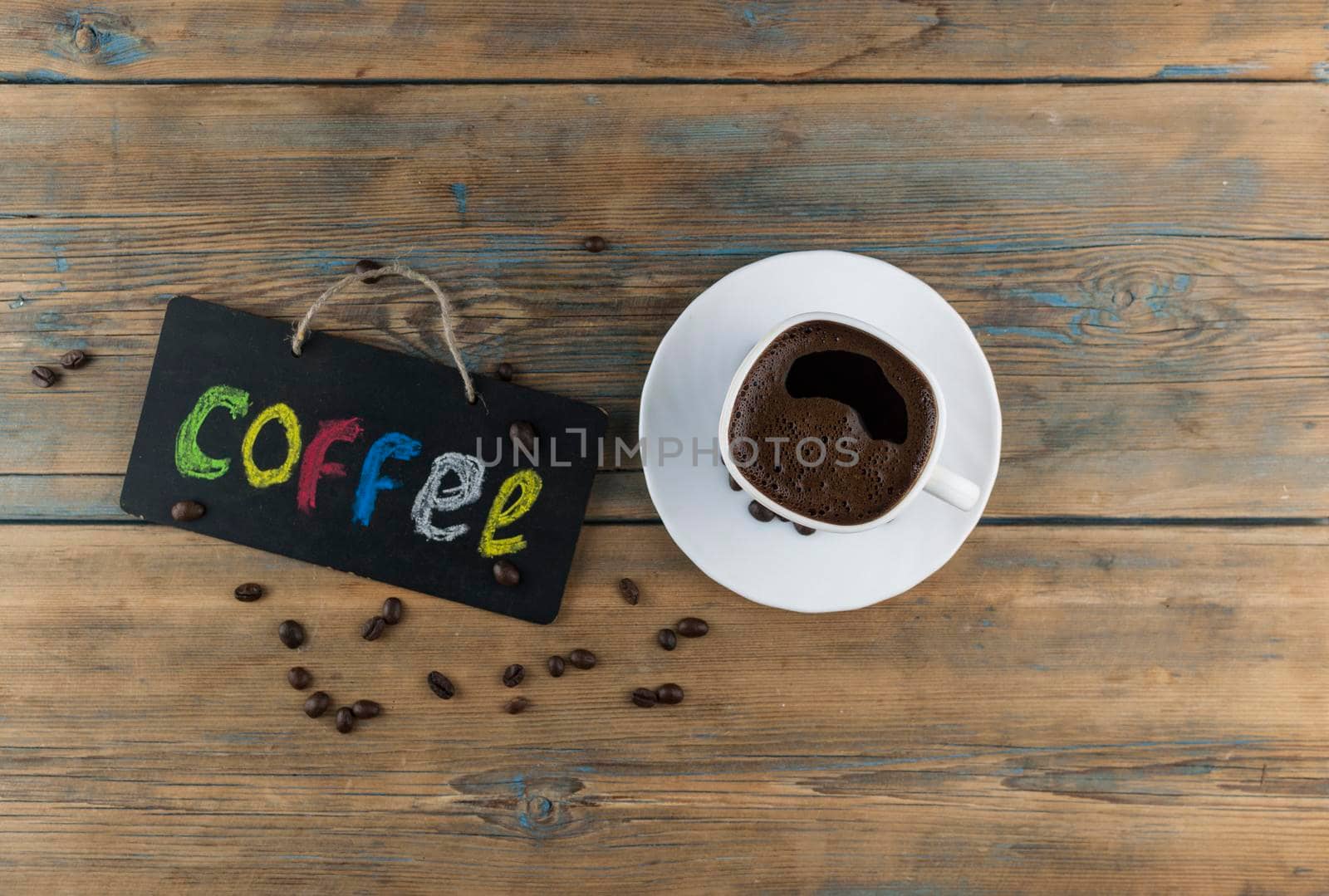 A cup of coffee and blackboard with inscription "coffee" writen colorful alphabet. Coffee break, morning awakening concept. by inxti