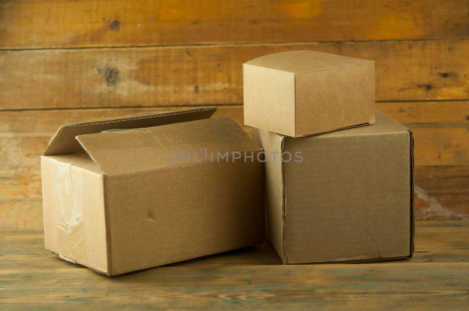 Pile cardboard boxes on a wooden background by inxti