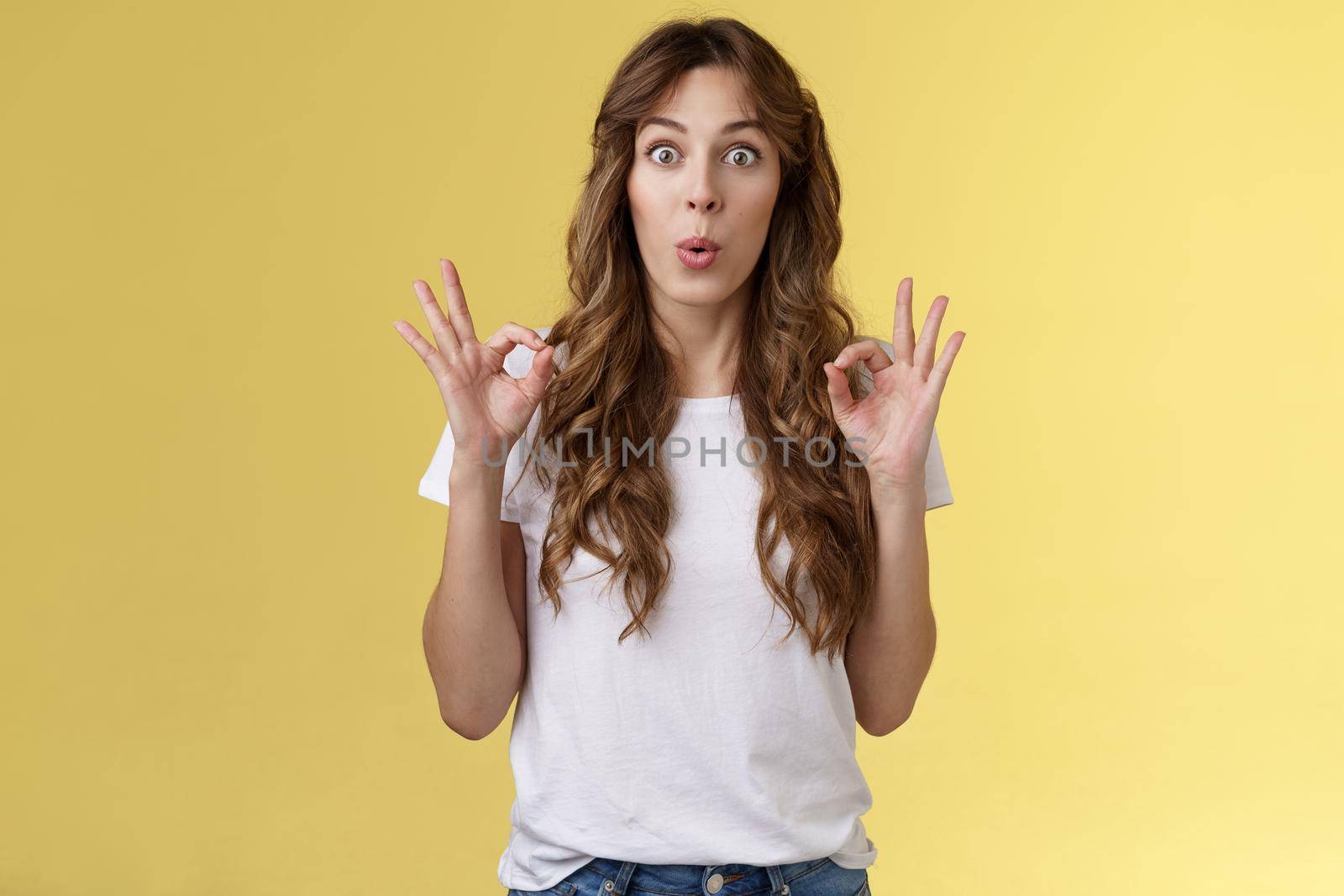 Wow was perfect excellent performance awesome. Impressed happy girl admire amazing friend effort show okay ok approval gesture like great idea folding lips temptation amazed yellow background.