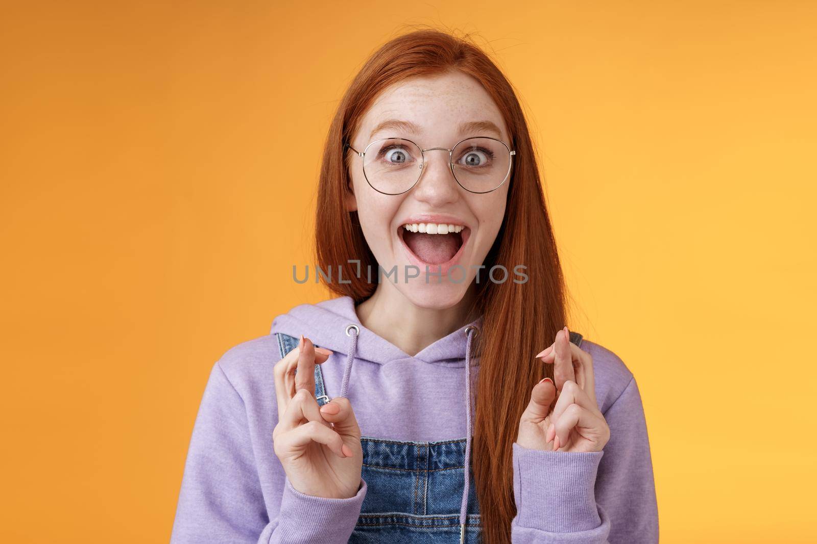 Lifestyle. Excited amused successful young redhead female student receive positive good news thrilled after praying crossed fingers good luck screaming happily rejoicing dream come true wish fulfilled.