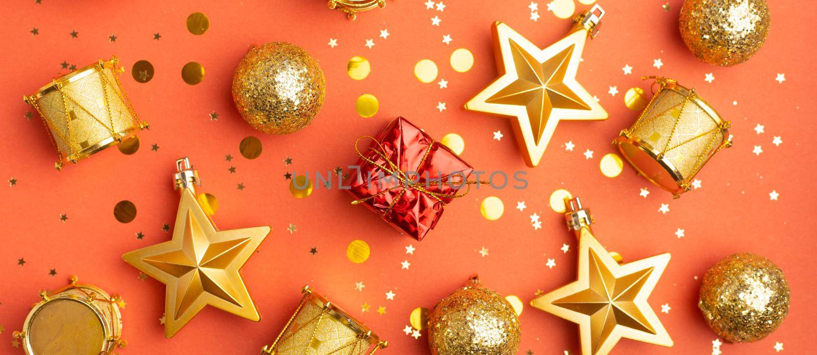 Layout of yellow Christmas toys on a red background . Christmas toys on a red background . Holiday. Festive decoration. Christmas Tree toys