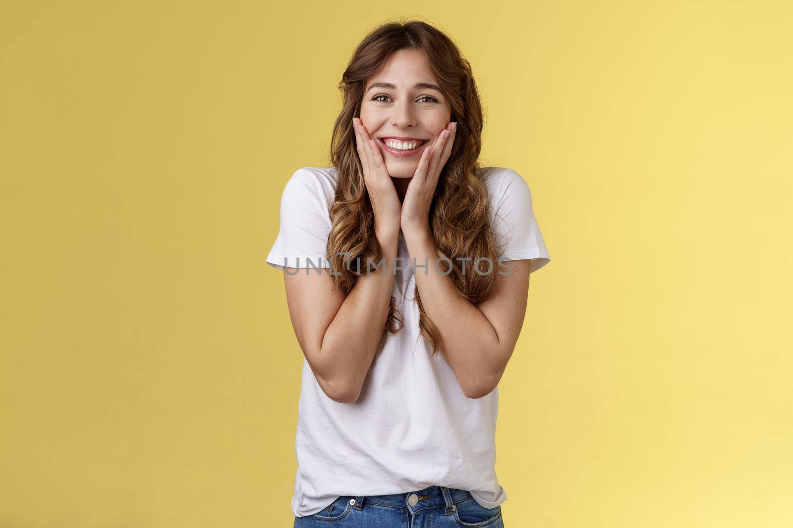 Cheerful happy upbeat young girl receive inredible opportunity study abroad student cheering celebrating stunning news touch cheeks blushing joy happiness smiling broadly yellow background.