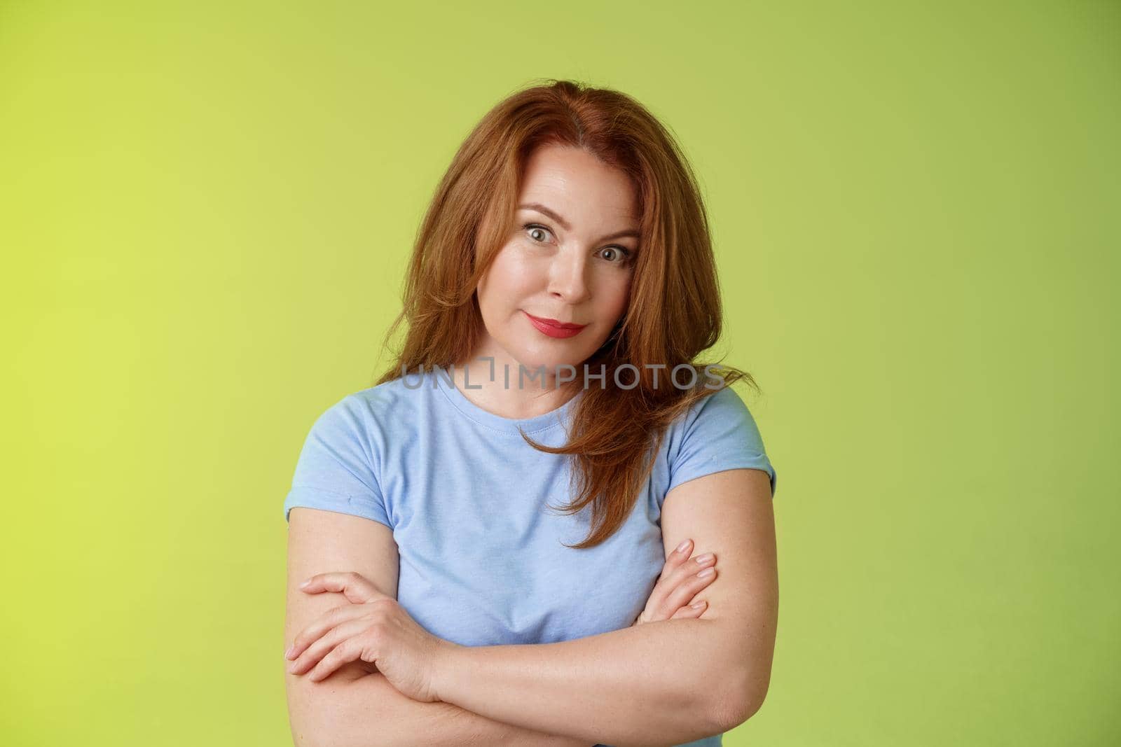 Confused shocked redhead mother look serious worried puzzled cross arms chest self-soothing calming gesture stare camera perplexed frustrated bad son behaviour stand green background disappointed by Benzoix