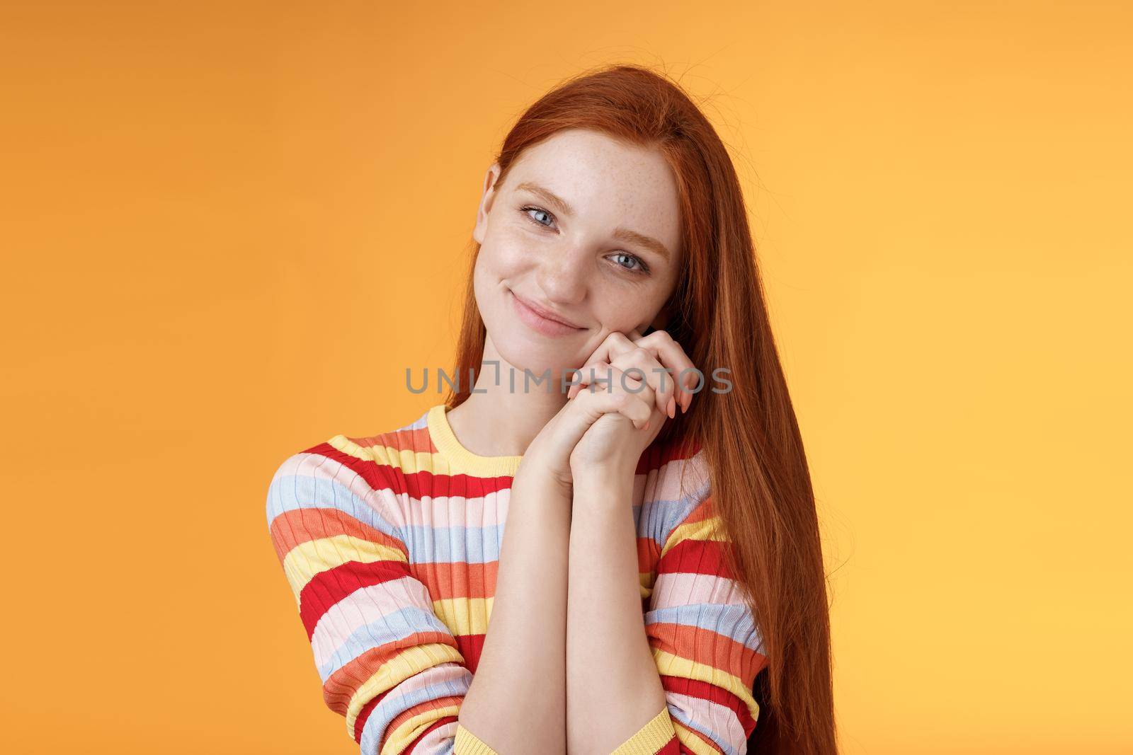 Dreamy sensual romantic young passionate redhead girlfriend melt heart feel sympathy joy receive sweet tender present lean palms smiling grateful gladly accept nice lovely gift, orange background by Benzoix