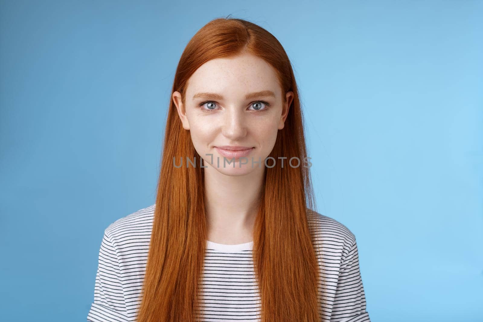 Excited good-looking confident young dreamy redhead girl blue eyes aimed success determined get job attend interview standing self-assured smiling friendly encourage herself, blue background.