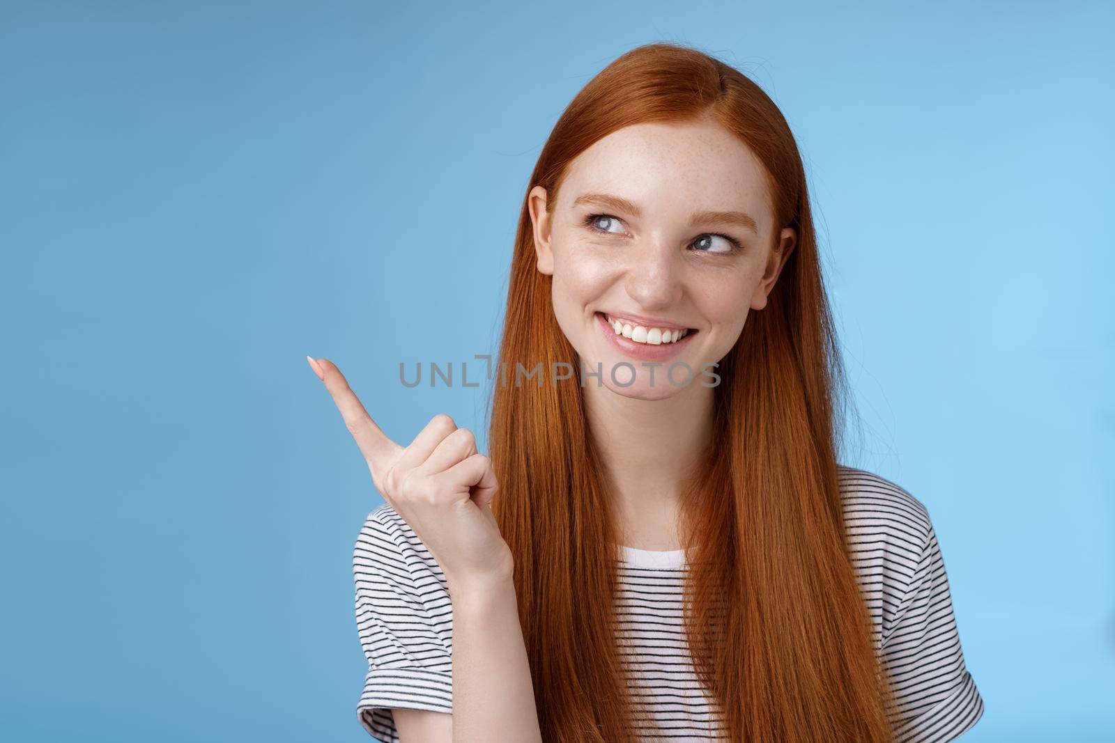 Wow interesting. Curious attractive smiling young 20s female student find good offer price product look pointing upper left corner intrigued grinning satisfied have perfect idea how use copy space by Benzoix