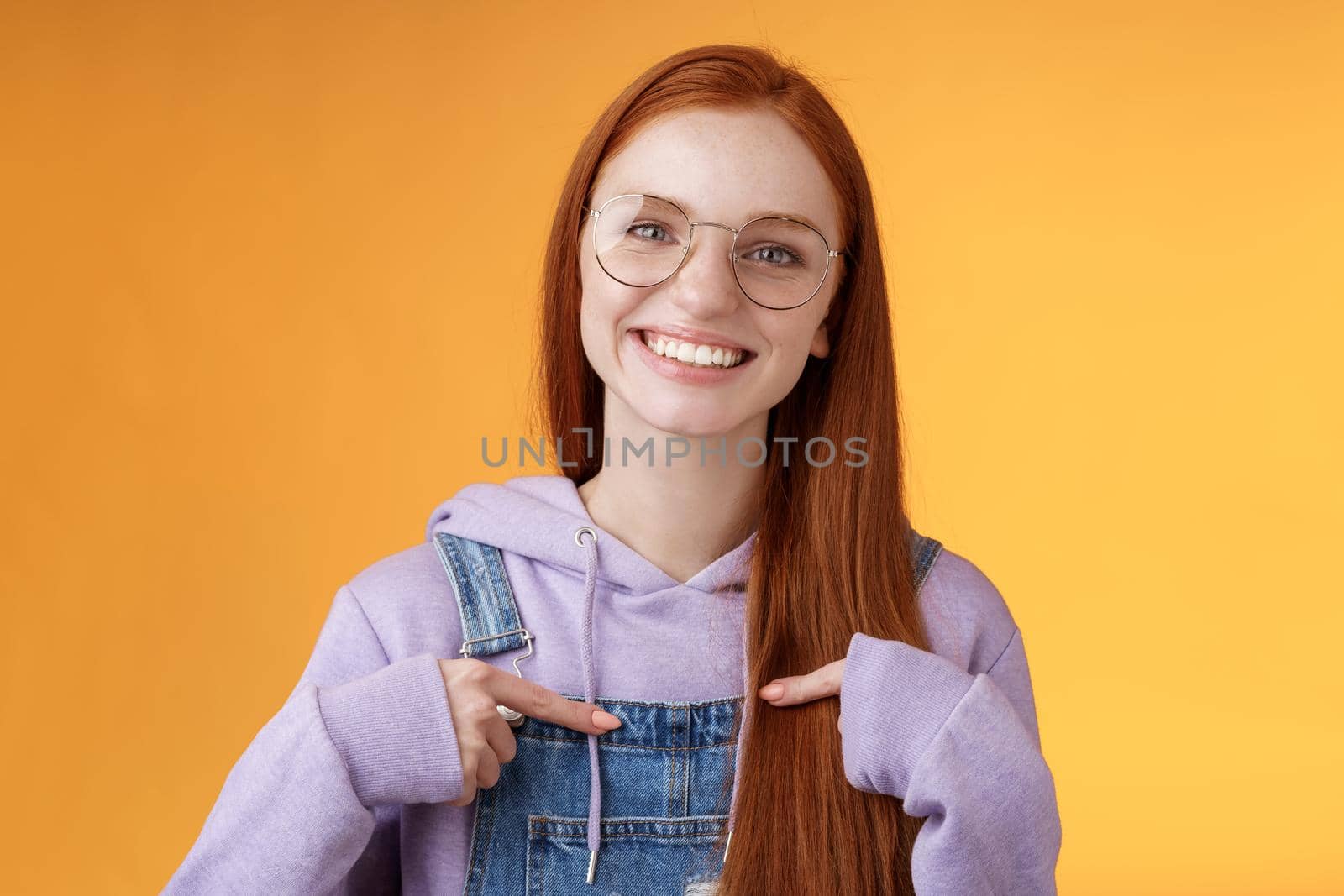 Happy lively friendly redhead european girl pointing herself suggesting help boasting telling own accomplishments smiling white teeth delighted volunteering, being picked, orange background by Benzoix