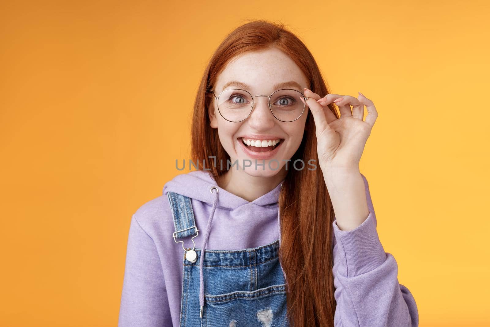 Happy enthusiastic young redhead girl amused find out excellent place celebrate b-day standing joyful excited touch glasses smiling broadly white teeth grinning rejoicing surprised, orange background by Benzoix
