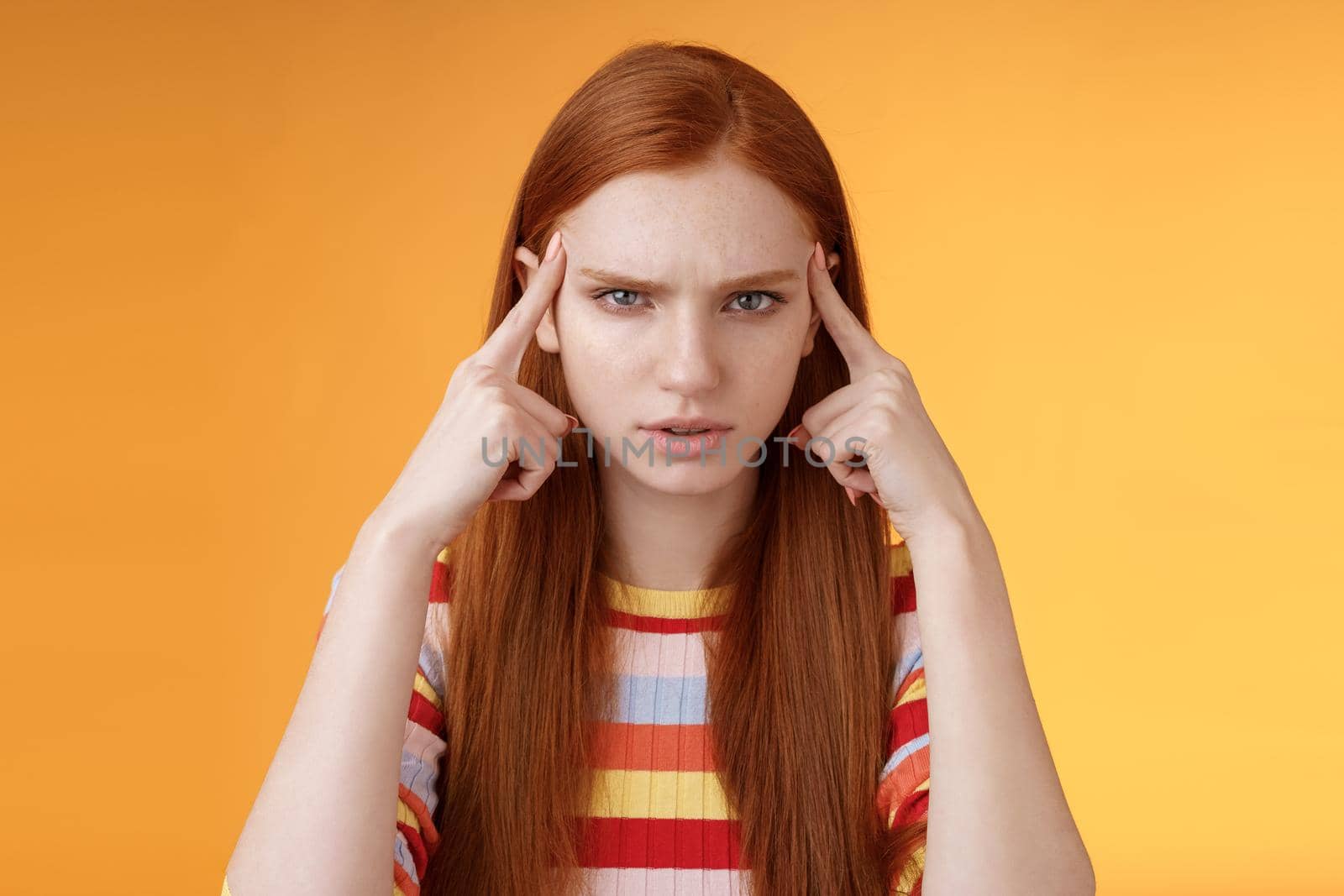 Puzzled serious-looking stressed-out young tired female student frowning look unhappy touching temples thinking trying focus, concentrate attention lecture memorizing hometask, orange background by Benzoix