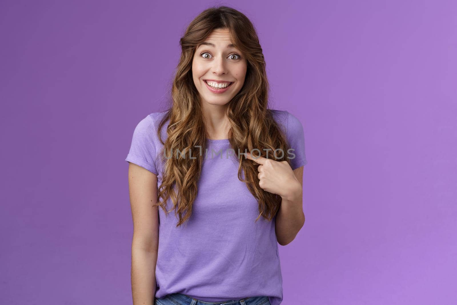 Who me awesome. Surprised silly tender delighted happy girl smiling impressed amazed pointing herself raise eyebrows astonished not expect hear own name stand purple background winning event by Benzoix