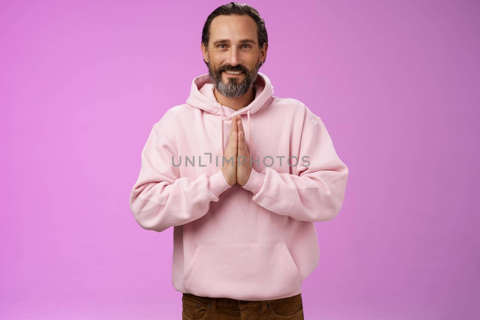 Peaceful attractive bearded mature mail model in trendy pink hoodie press palms together namaste praying gesture smiling delighted relaxed bowing buddhism faith, appreciating help, look thankful by Benzoix