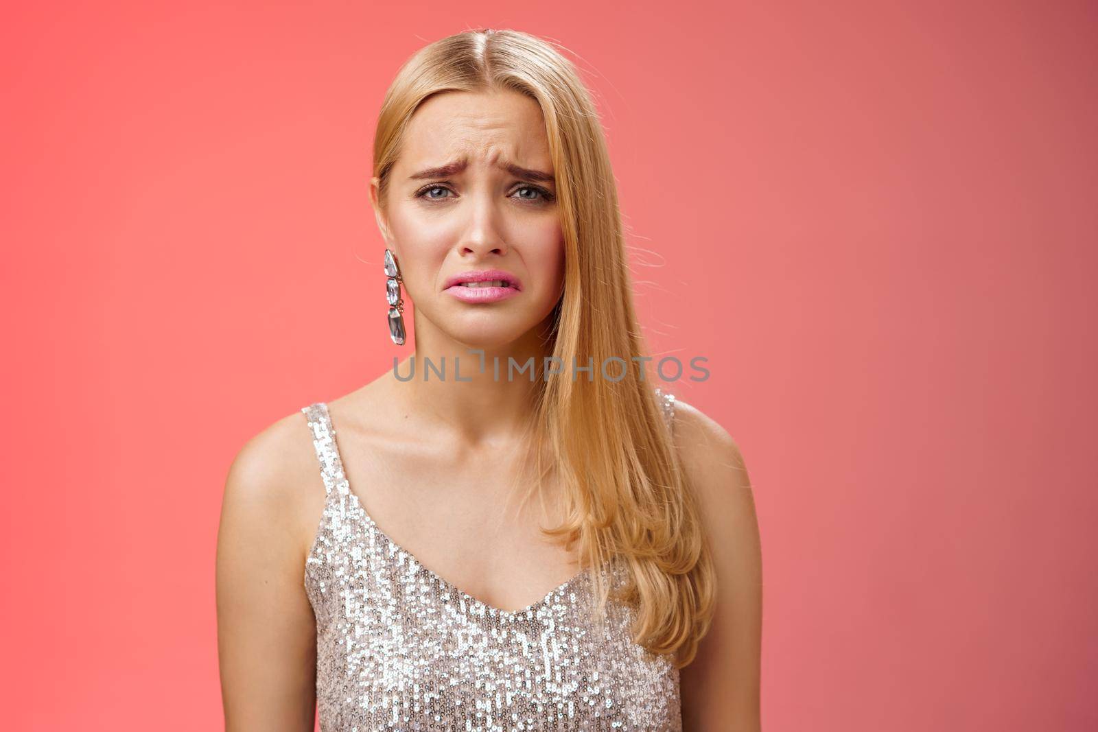 Disappointed complaining cute blond woman in silver stylish dress grimacing frowning upset have bad day pouting pity standing displeased unhappy heartbroken everything bad, red background by Benzoix