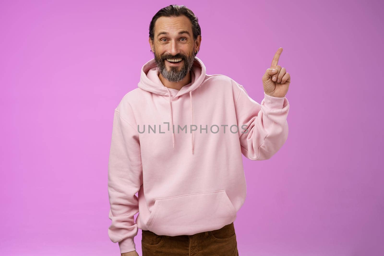 Handsome excited mature 40s bearded man wrinkles grey hair laughing happily acting immature having fun amusing vacation trip pointing up astonished smiling impressed surprised, purple background by Benzoix