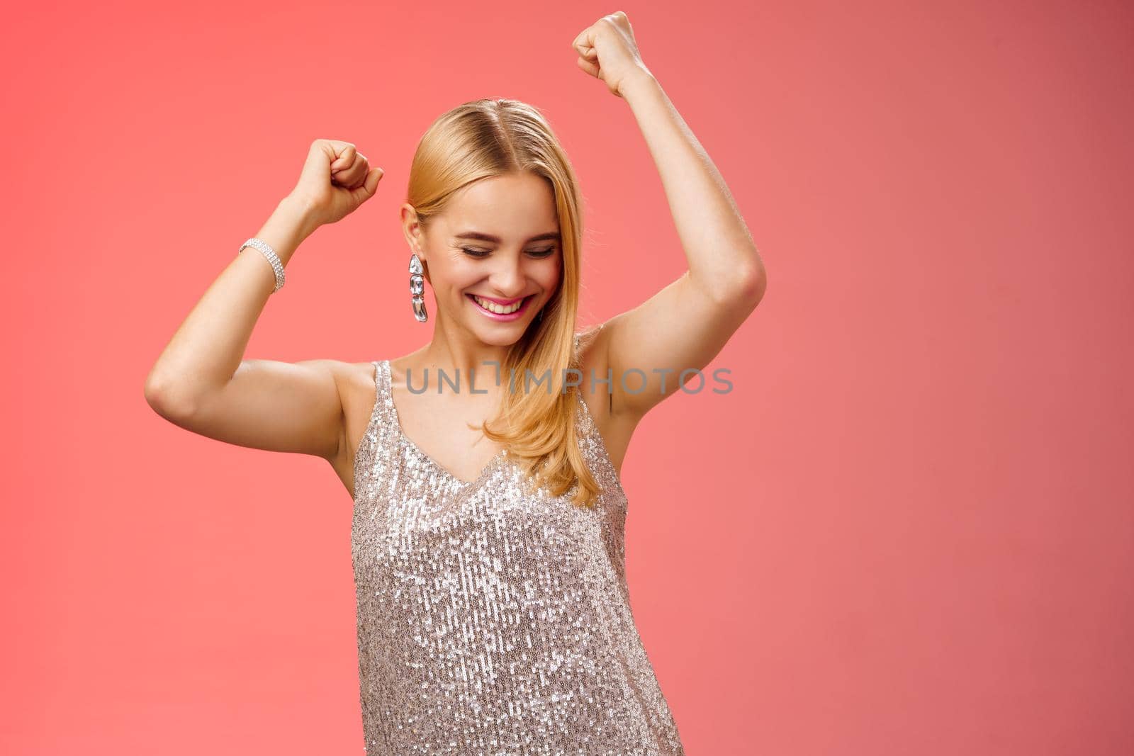 Joyful blond excited birthday girl having fun carefree dancing raised hands close eyes smiling enjoying night-out girlfriend nightclub have fun standing amused red background entertained by Benzoix