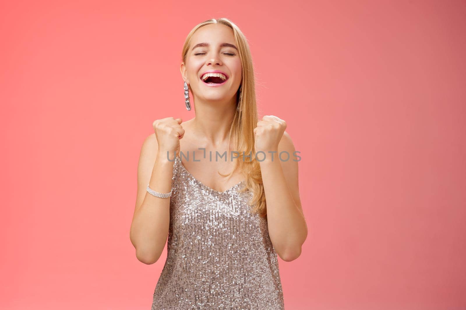 Lifestyle. Girl finally achieve goal say yes relieved happily clench fists close eyes triumphing celebrating victory standing thrilled in glittering luxurious dress winning first prize fashion contest.