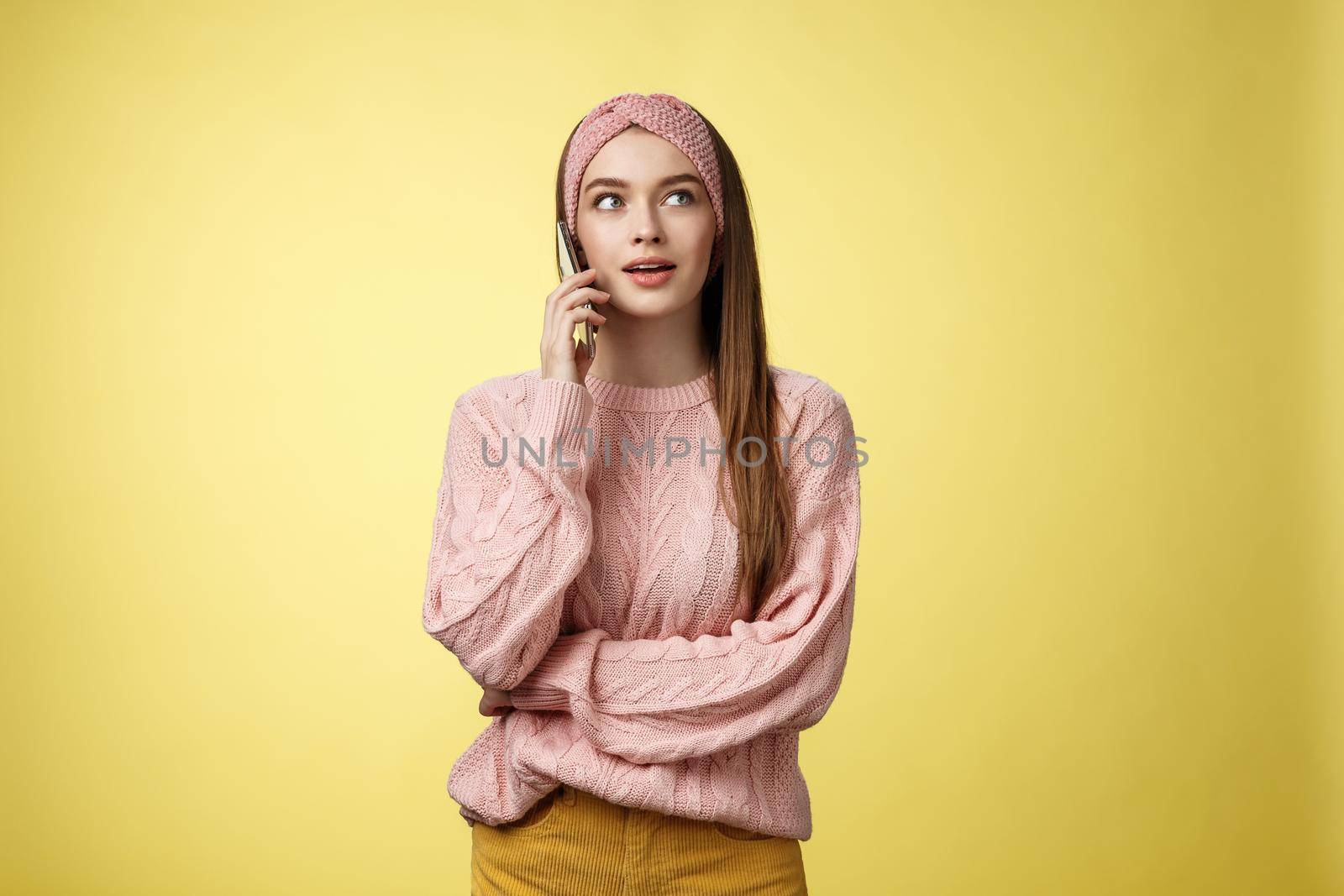 Attractive female office manager making table reservation calling restaurant via smartphone chosing menu for delivery, looking up thoughtful holding mobile phone near ear talking, waiting response by Benzoix