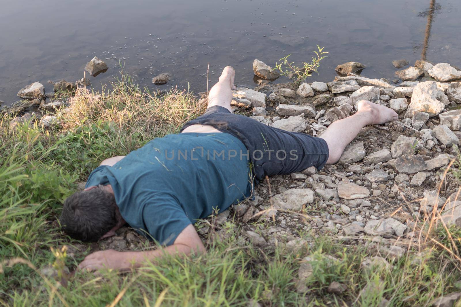 the body of a man dead from drowning lies on the riverbank. artistic photo painting, selective focus ,