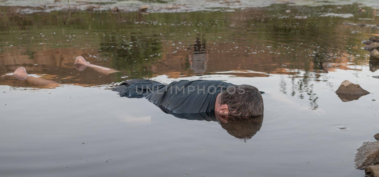the body of a man who drowned, lying face down in the water lifeless body. artistic photo painting, selective focus ,