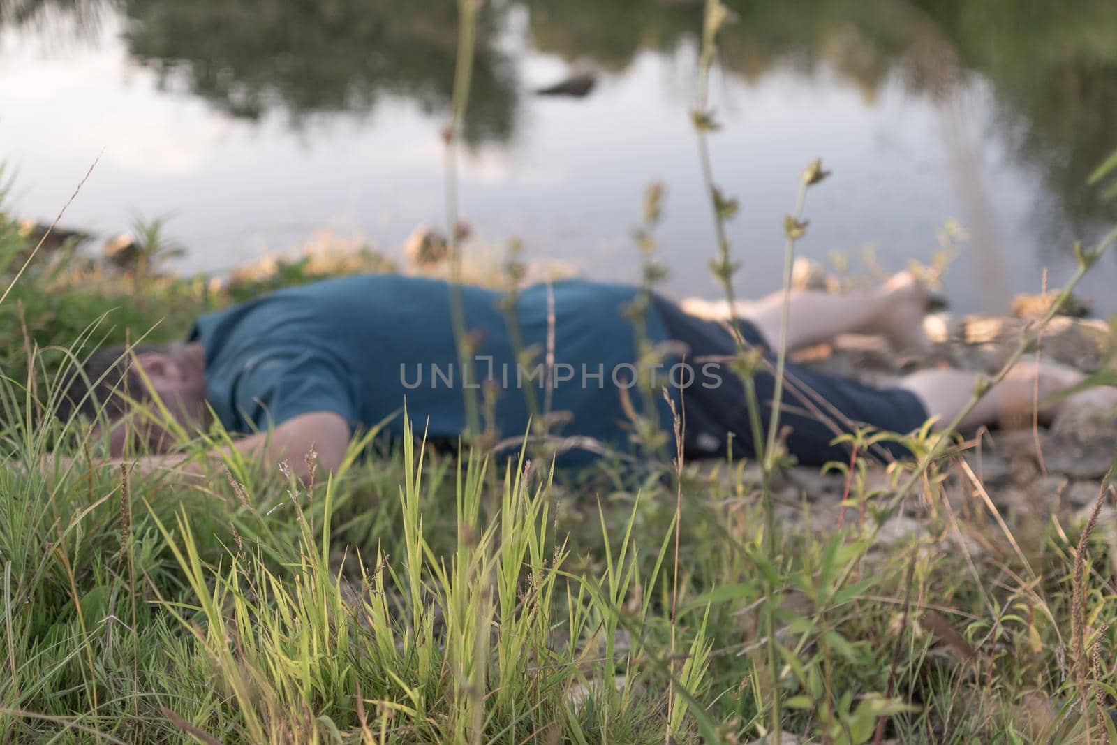 the corpse of a dead man lies on the shore by the water.artistic photo painting, selective focus ,