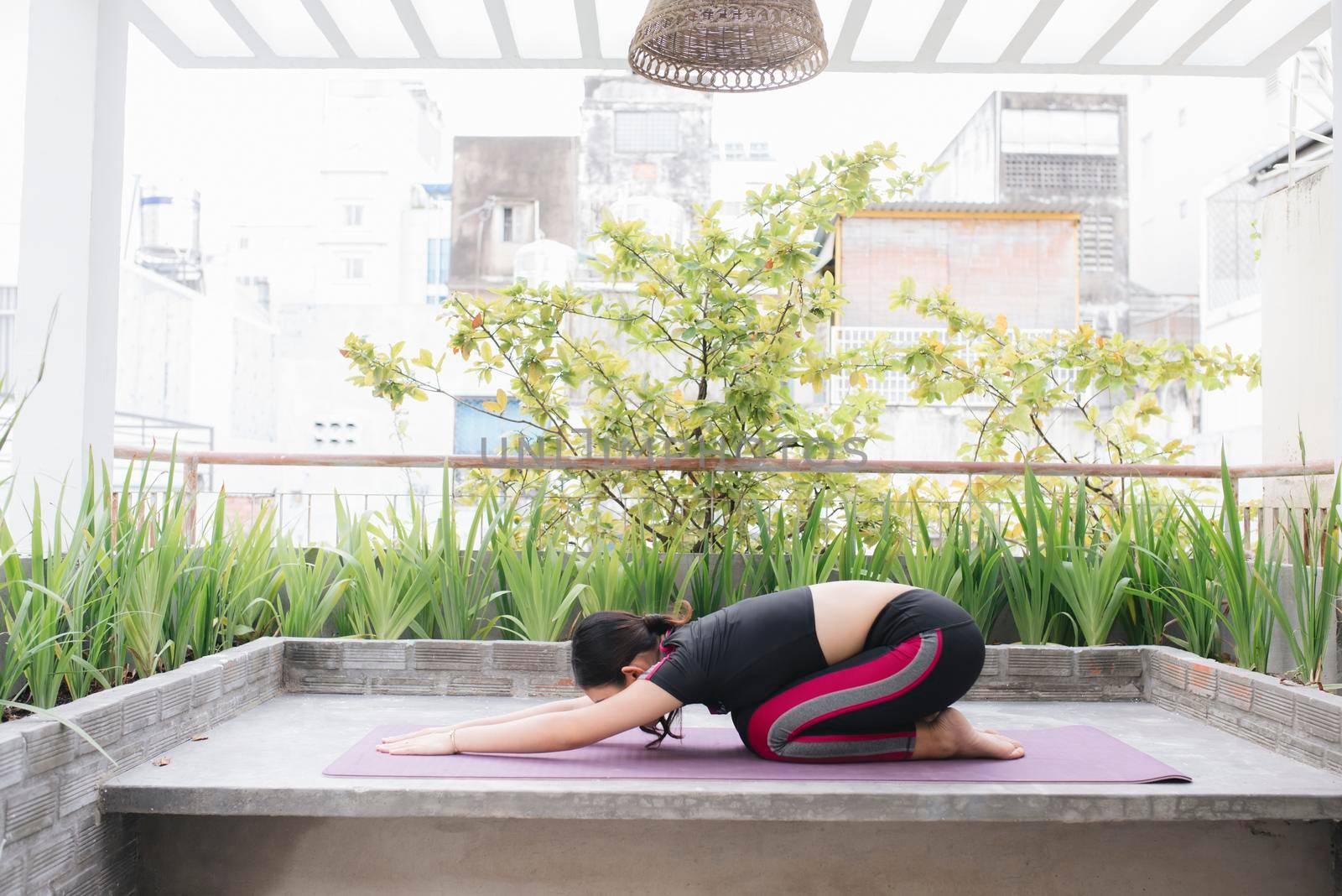 Asian woman relax in the holiday. Play if yoga. On the balcony