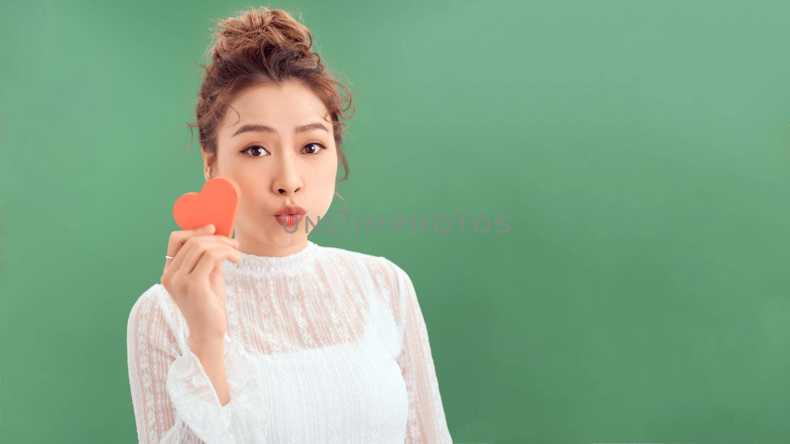 Portrait of happy romantic girl with red paper heart-shaped postcard, romantic wishes, Valentine day celebration, love concept