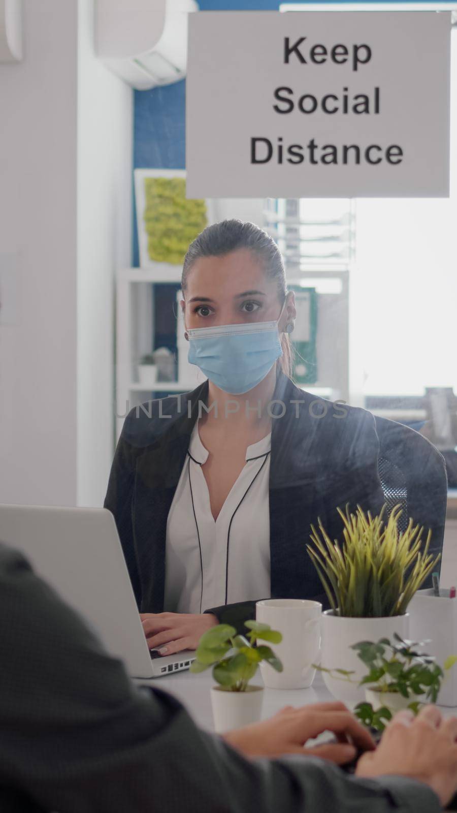 Freelancer with face mask working at financial graphics on pc by DCStudio