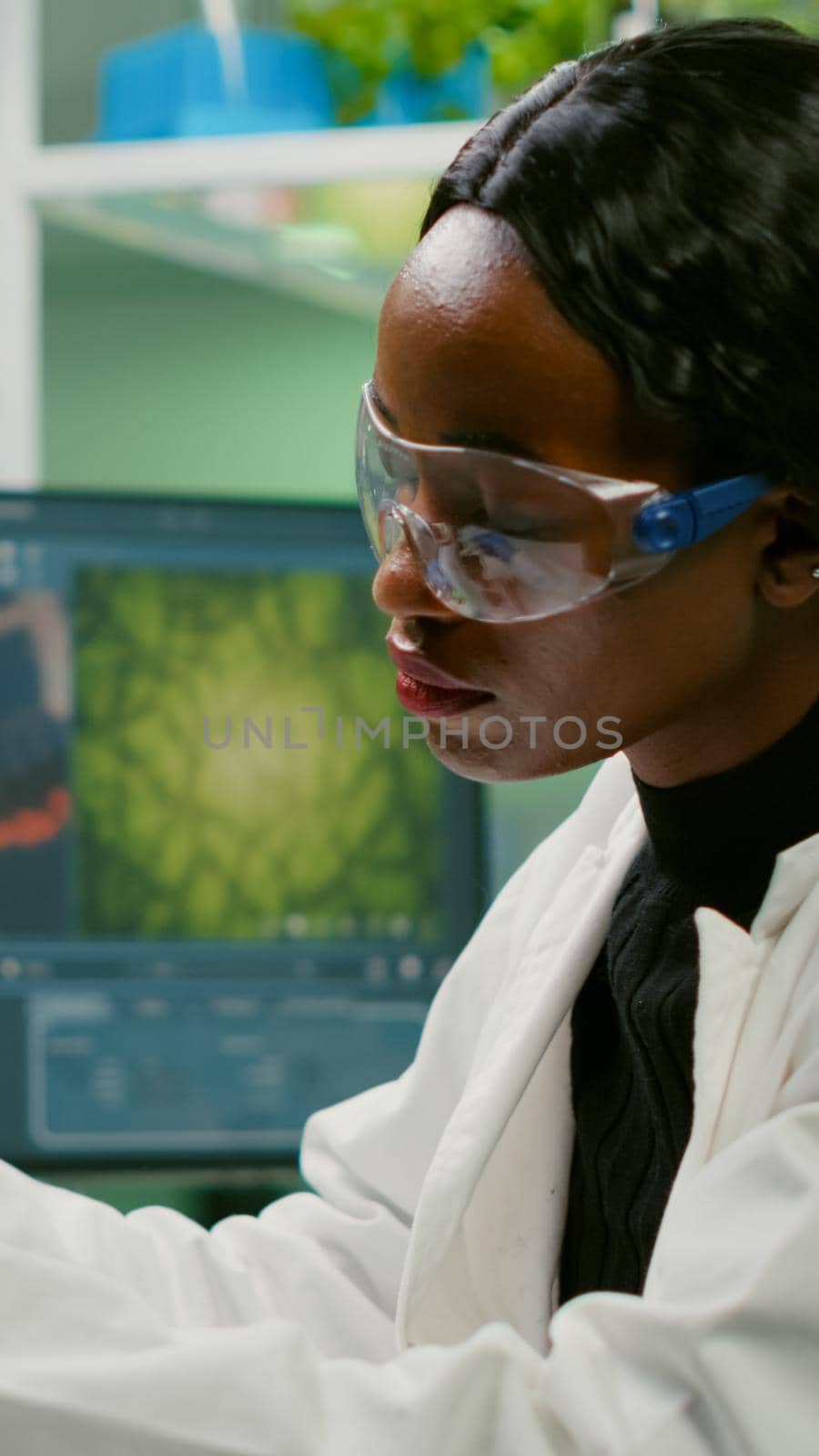 Biotechnology scientist examining botany green leaf using biological microscope researching medical expertise. Chemist analyzing organic agriculture plants in microbiology scientific laboratory