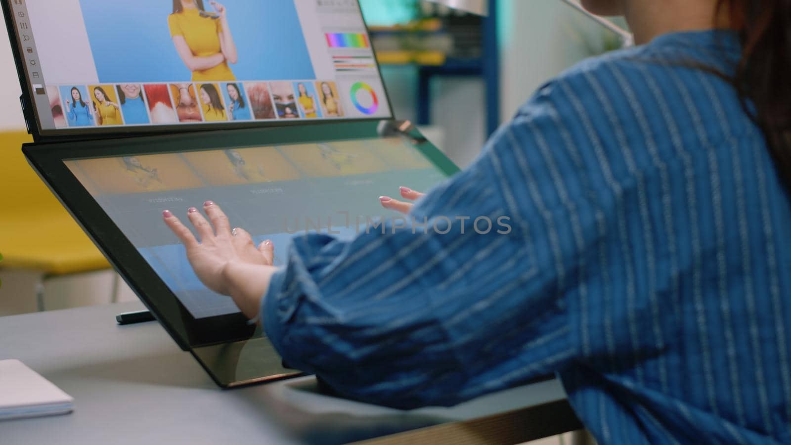 Close up of photographer hands using touch screen monitor to retouch photos at studio. Woman working as media editor retouching pictures with editing app on computer for image production