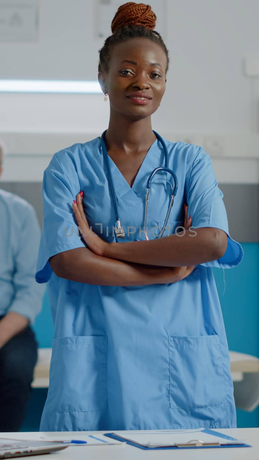 Portrait of medical assistant wearing uniform standing in cabinet by DCStudio
