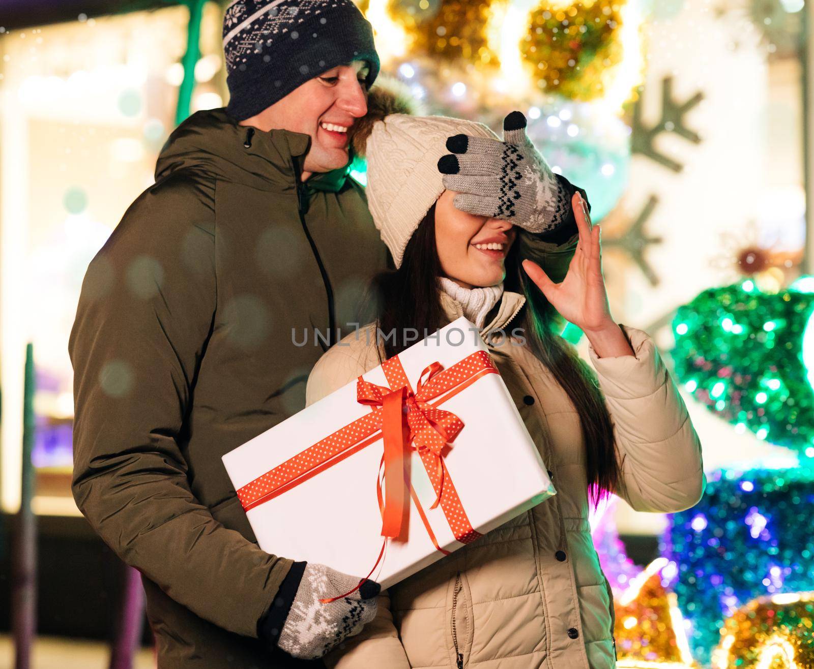 Boyfriend Making Holiday Surprise to His Woman Celebrating Together Giving Christmas Present. Lovely Couple Stand. Gift Box Hugging Outdoors.