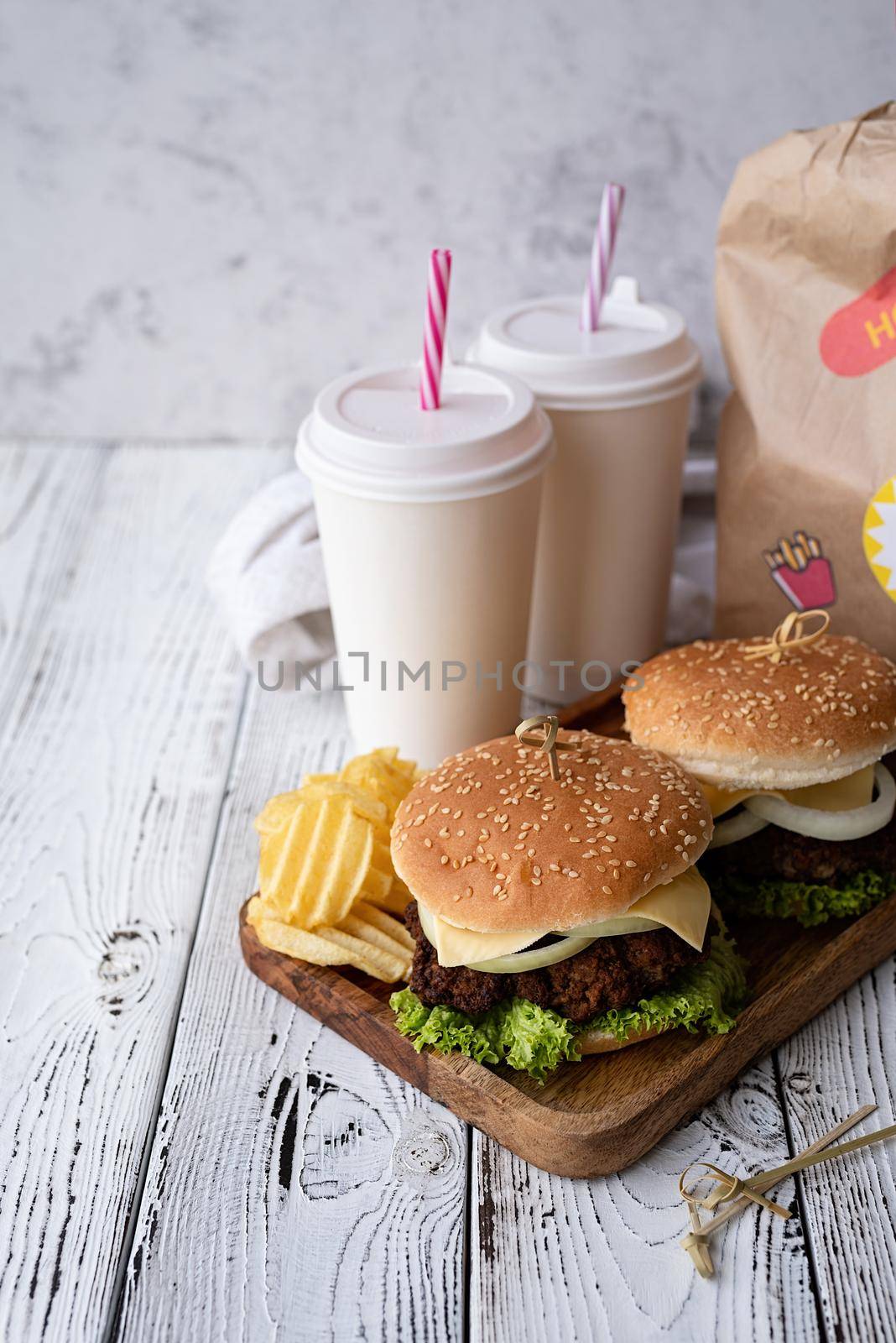 Fat unhealthy food close-up. Set of homemade burgers, chips and drink