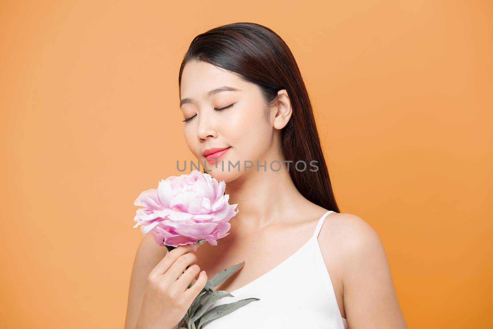 woman holding peony bouquet over yellow