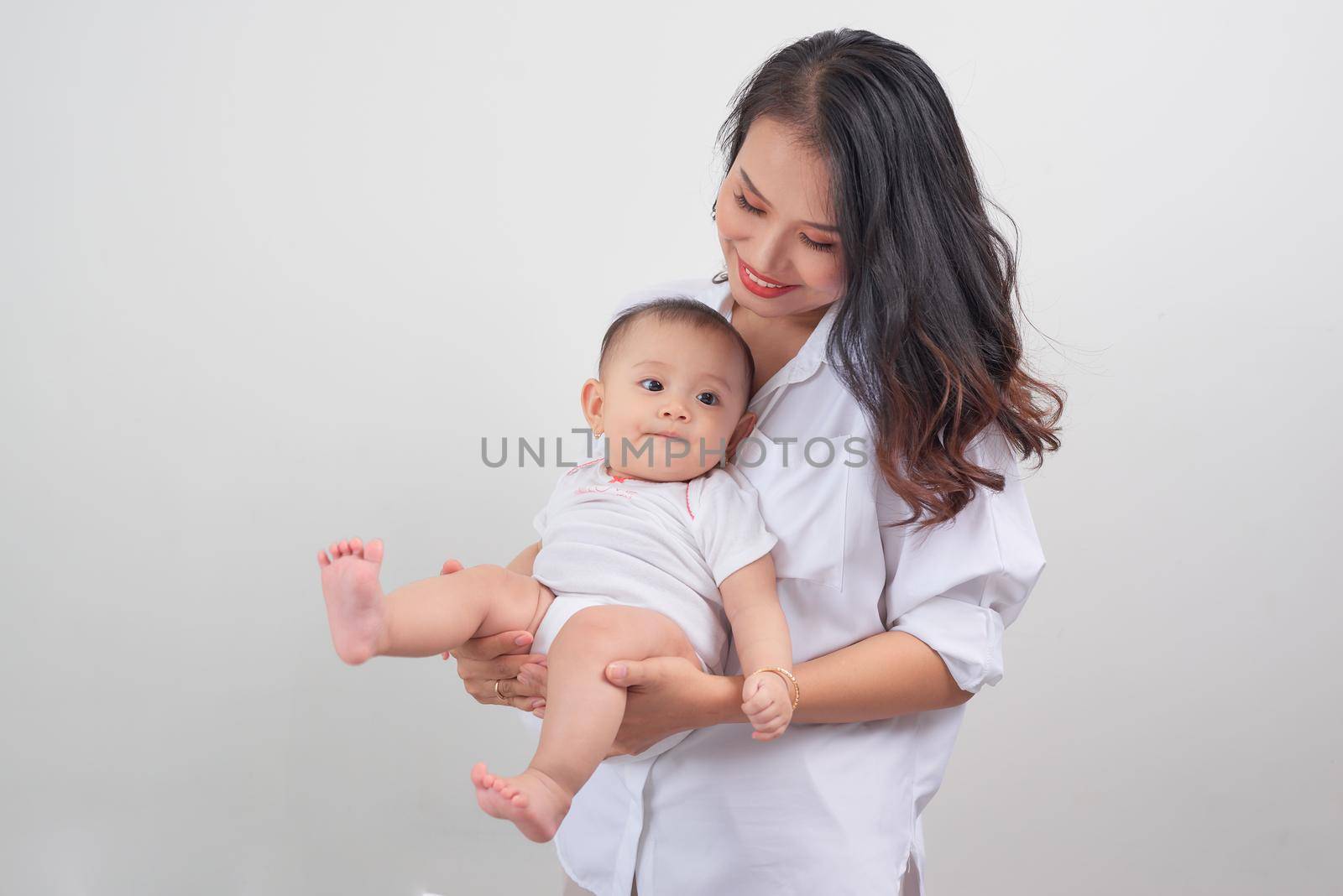 Safe in his mother's arms. Mother and her baby girl at home. by makidotvn