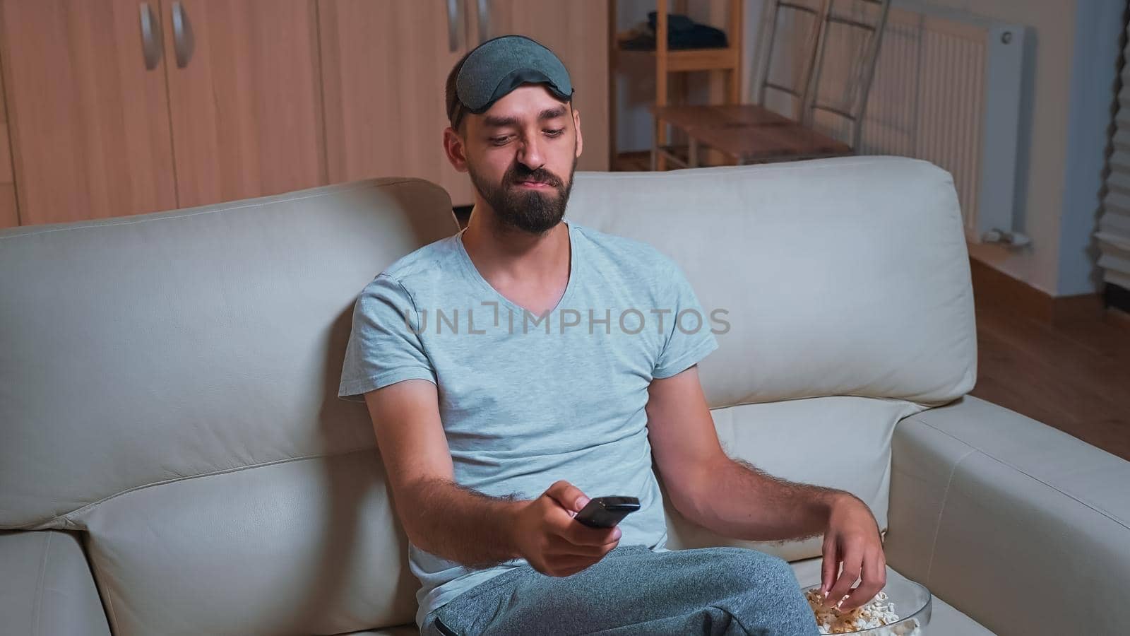Interested man with beard relaxing in front of television while looking at entertainment movie by DCStudio