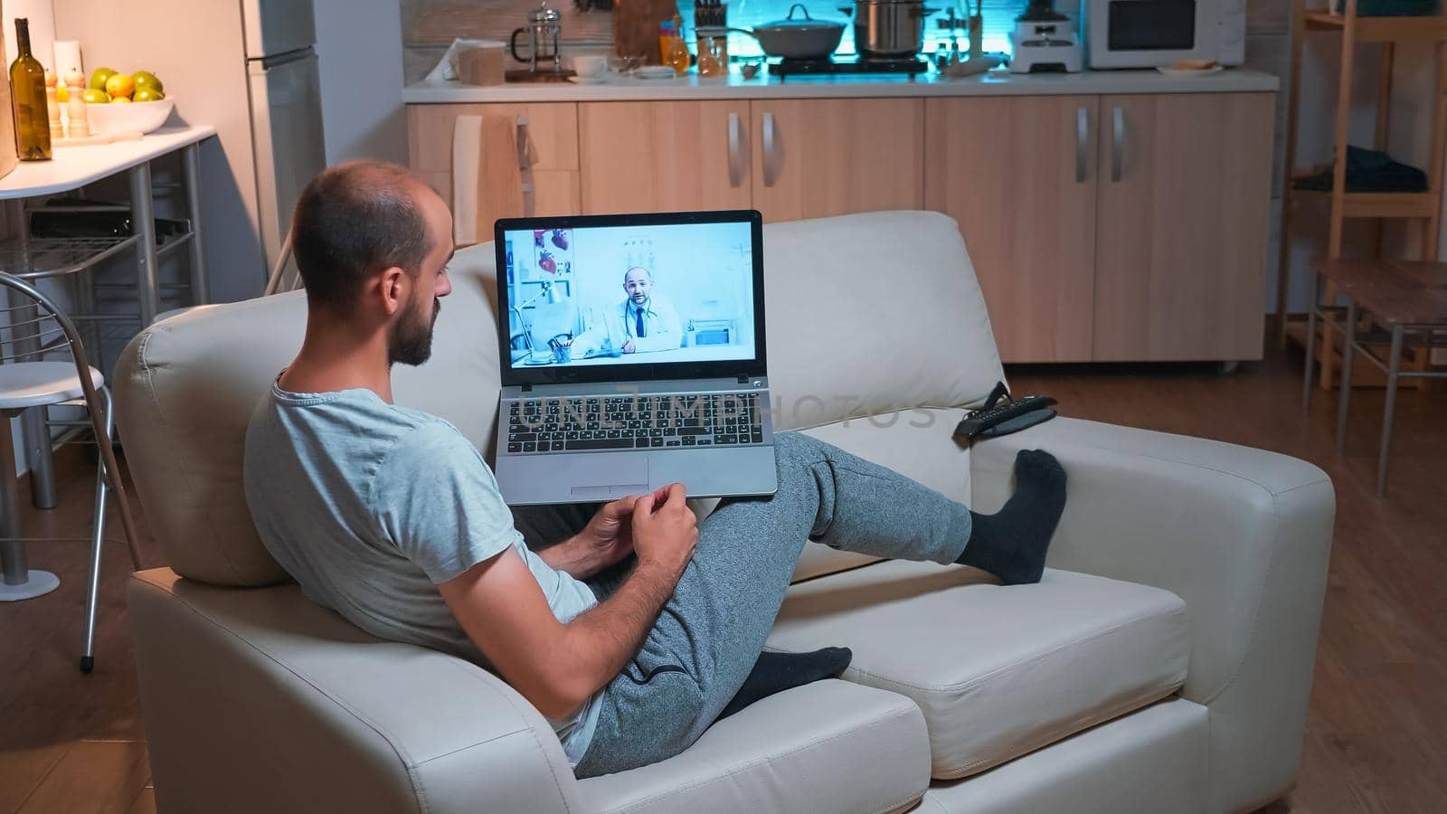 Unhealty man talking with physician doctor about covid-19 treatment during online videocall appointment. Caucasian male sitting in front of laptop computer disscusing about virus symptoms