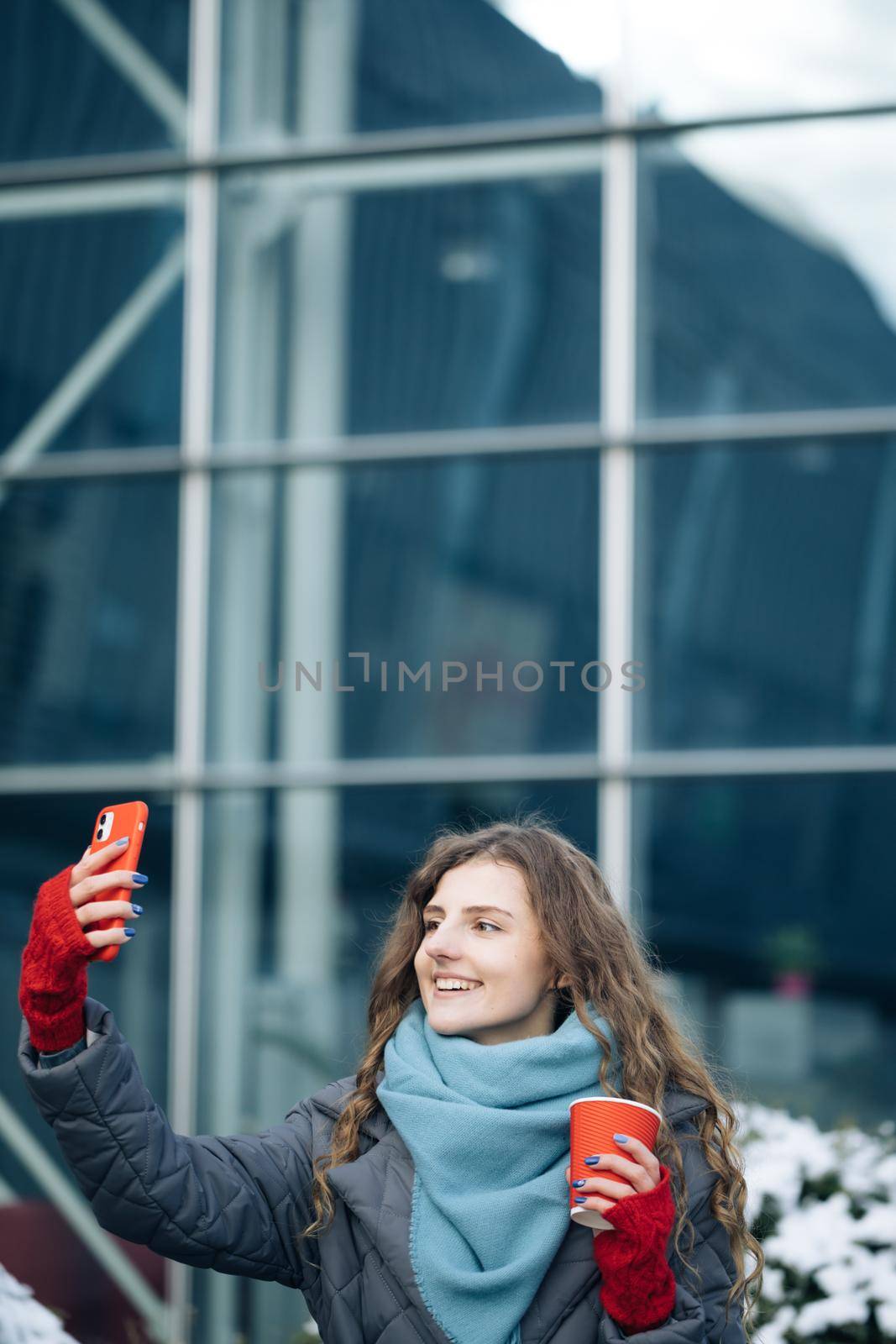 Cheerful woman recording video for vlog in social media or making a video call. Female looking at camera talking with friends and making video conference call record lifestyle blog vlog outdoor.