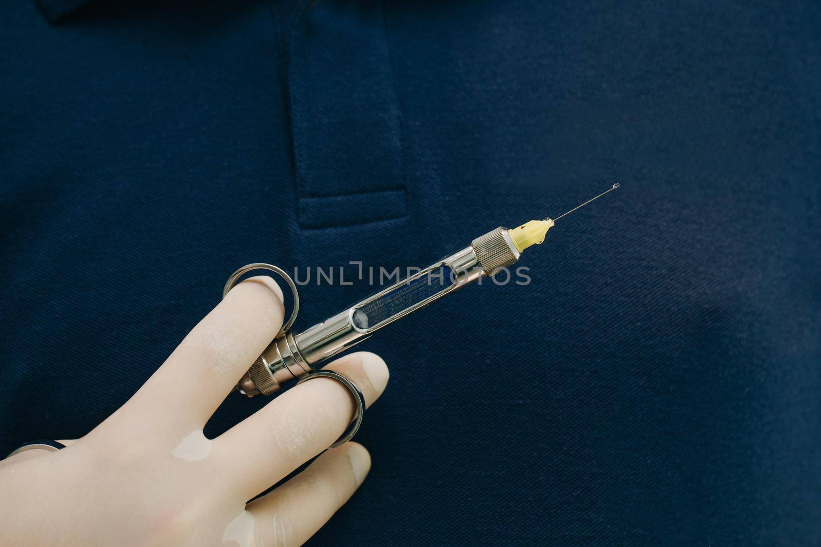 Dentist hand in glove holding syringe anesthesia. Close up of doctor holding syringe with dental anesthetic. Medicine, dentist, and health care concept. by uflypro