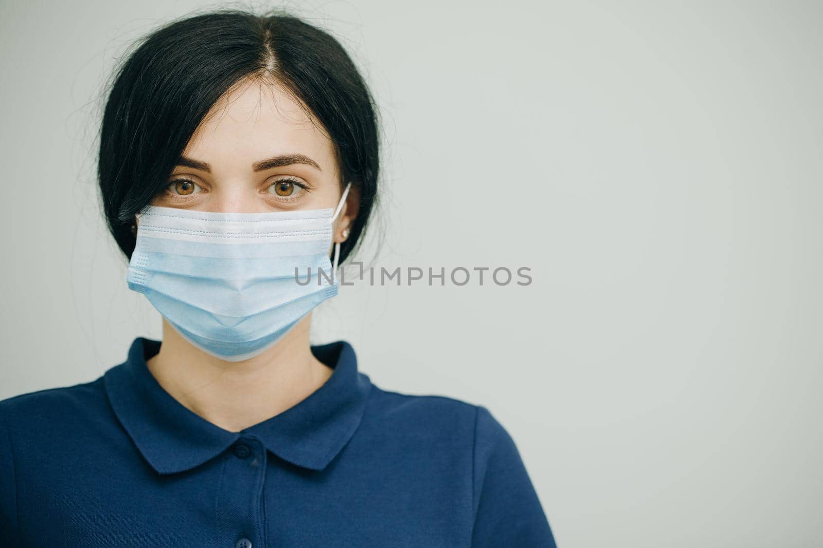 Health Protection Corona Virus Concept. Young woman in medical mask. Female breathes deeply and looking at camera. by uflypro