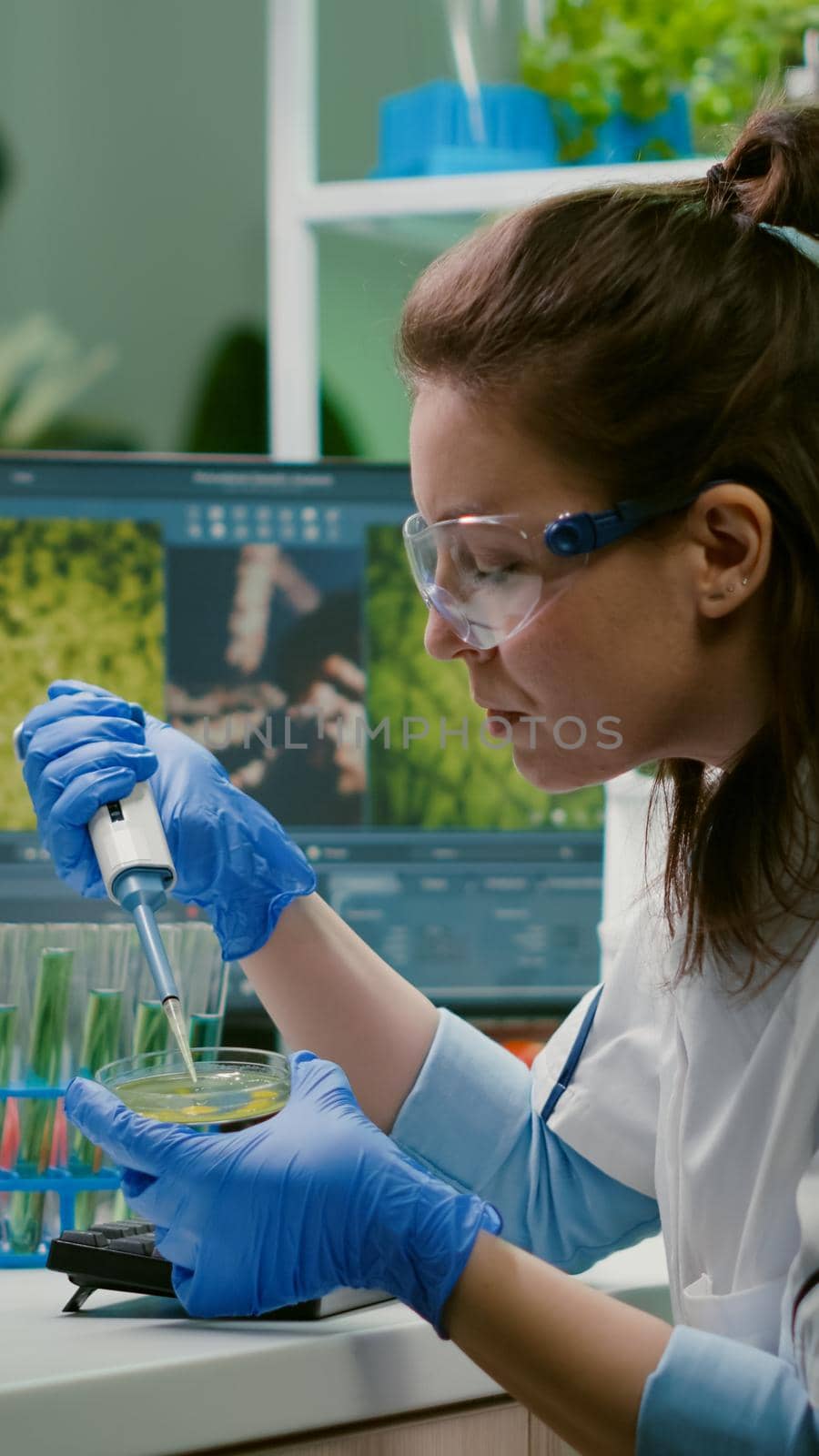 Chemist woman taking dna liquid from test tube with micropipette by DCStudio