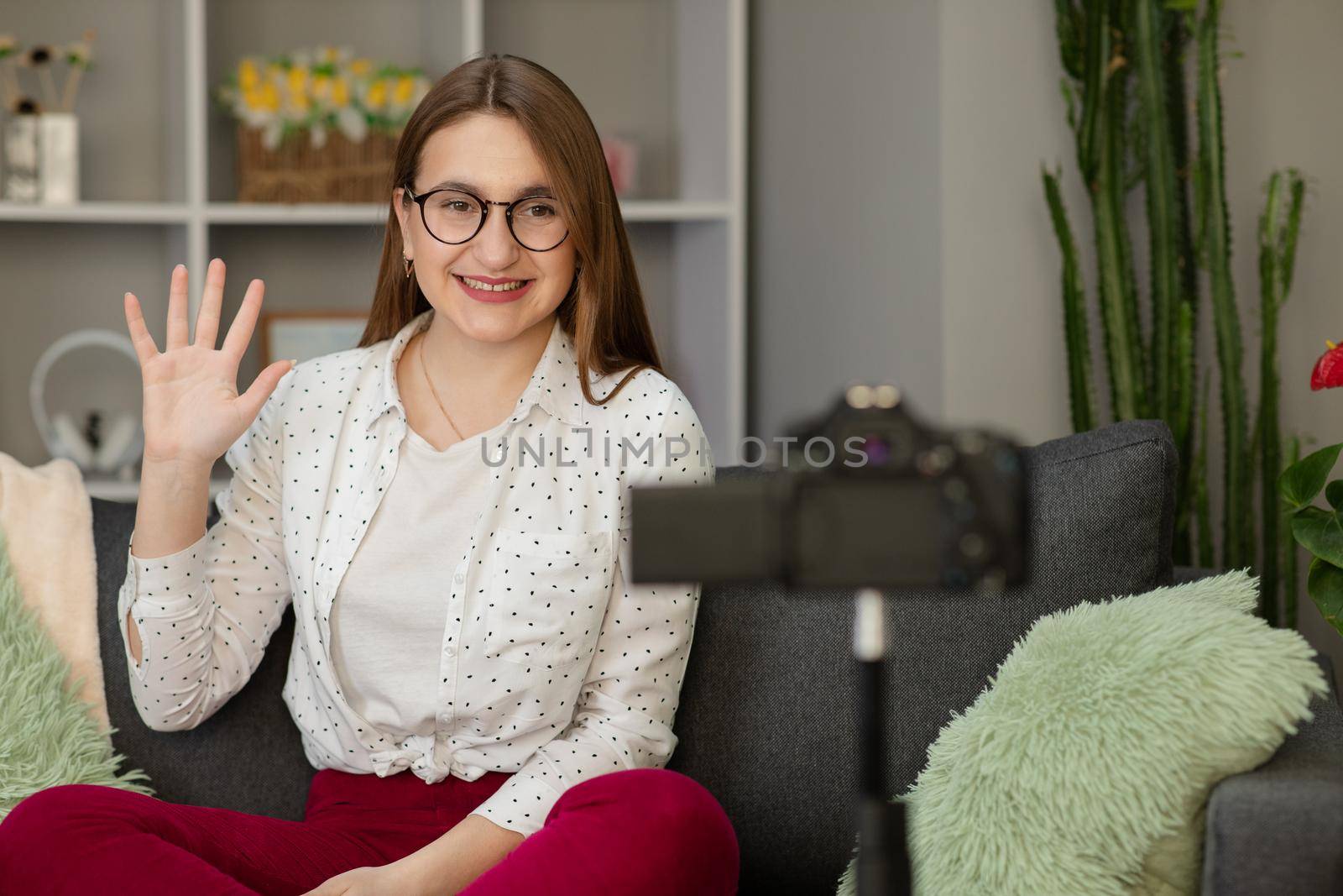 Happy young woman vlogger waving hand speaking looking at camera webcam, friendly girl communicating with friend online make video call talking record lifestyle vlog distance job interview