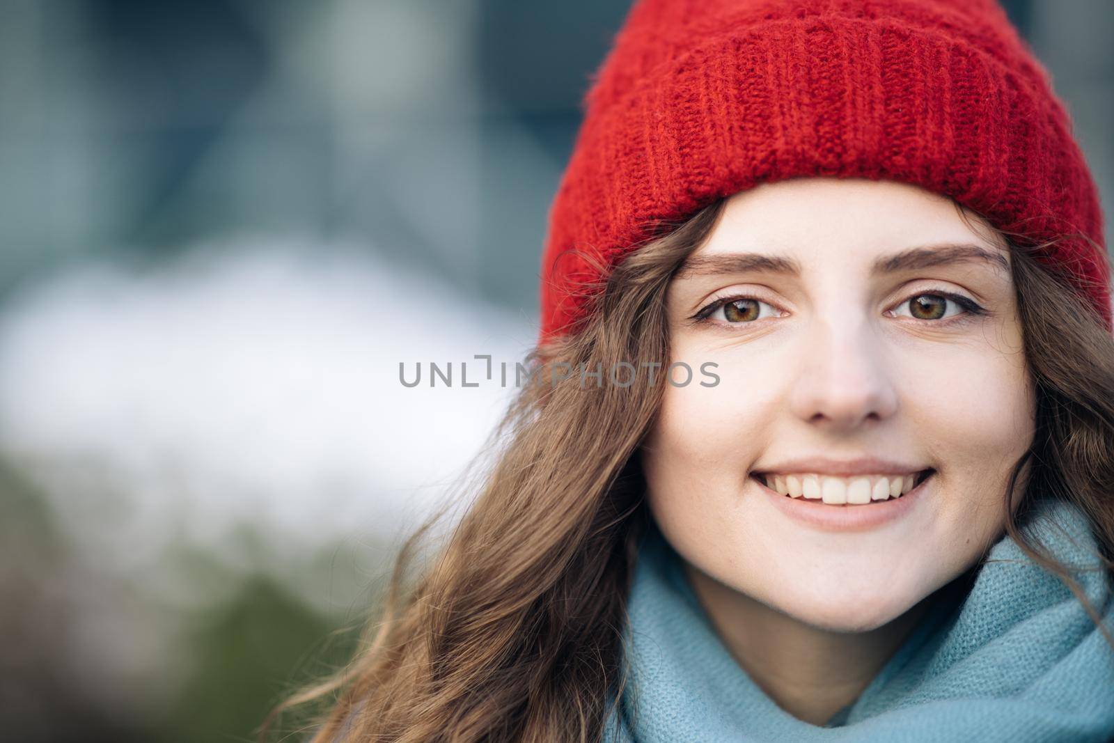 CLose up Portrait young attractive curly haired smile woman with red hat look at camera at city center feel happy. Fshion girl. Stand on street by uflypro