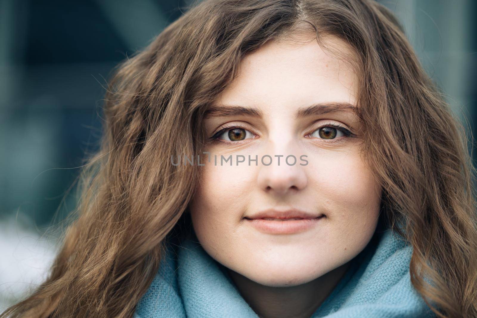 Attractive serious Face young woman looking at camera beautiful curly hair stand on street city lifestyle winter girl city outdoors