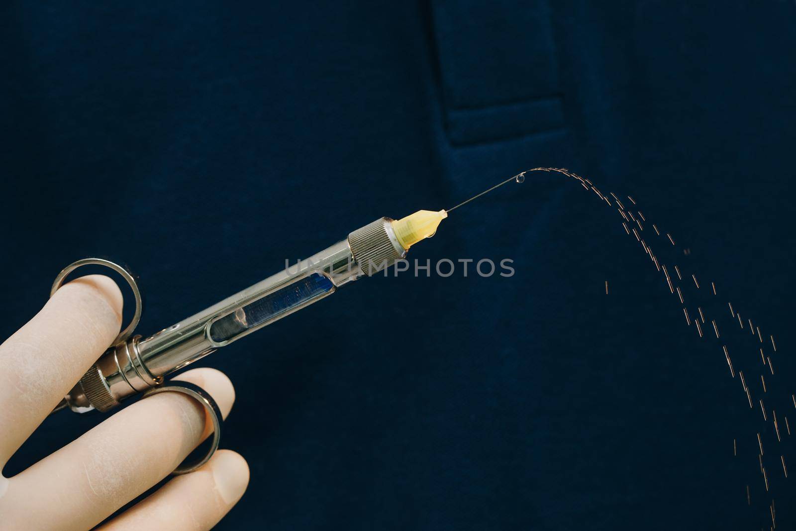 Close up of doctor holding syringe with dental anesthetic. Medicine, dentist, and health care concept. Dentist hand in glove holding syringe anesthesia. by uflypro