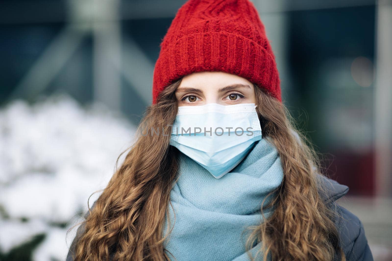 Pandemic coronavirus covid concept. Curly brunette woman in surgical protective mask for corona virus second outbreak prevention. Girl with protective mask on face.